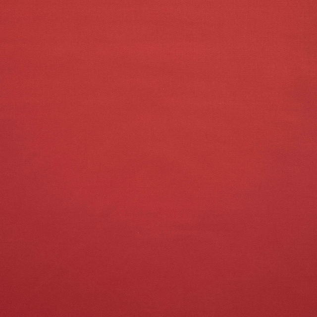 Close-up of plain deep ruby-red fabric with a fine, subtly textured weave