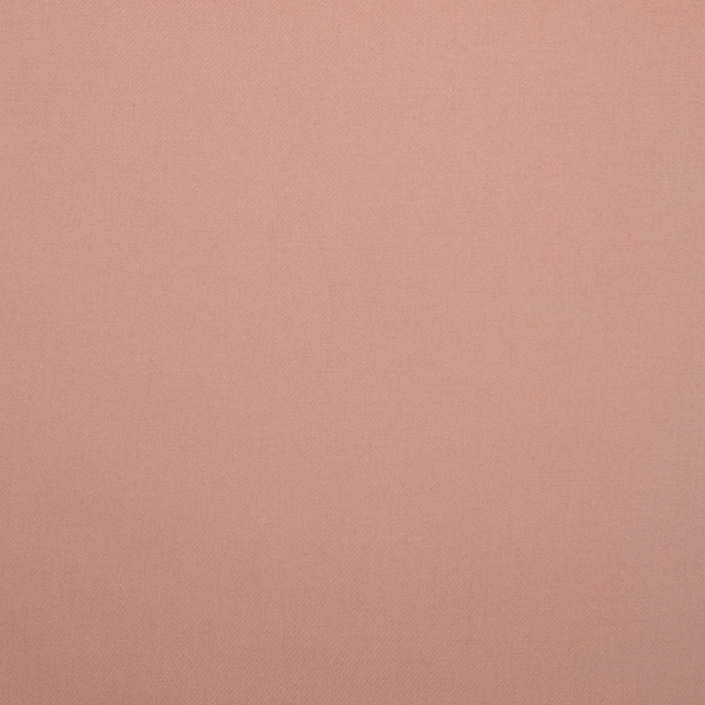 Close-up of plain dusty rose-pink fabric with a softly textured woven surface