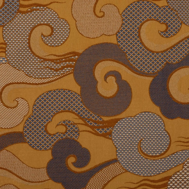 Amber ochre textile with charcoal paisley curls, crosshatch panels and fine wave lines