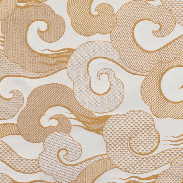 Cream textile with warm sable scrolls, curling paisleys and crosshatched motif details
