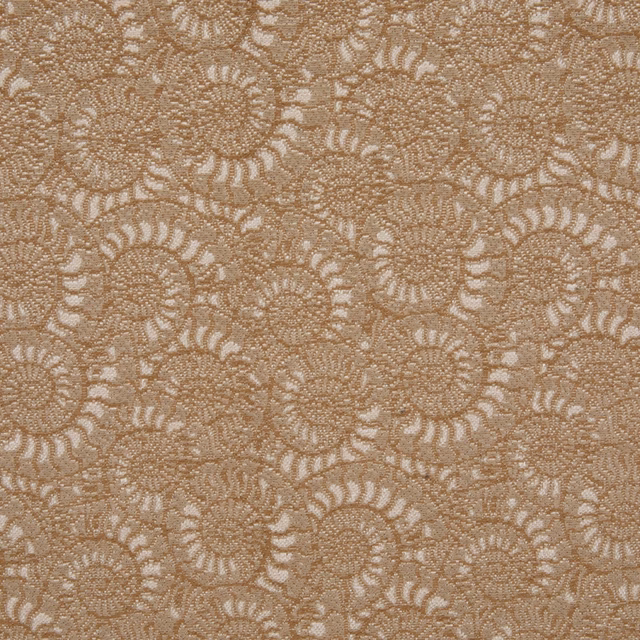 Warm ochre-beige textile with densely packed cream spiral-shell motifs and fine woven texture