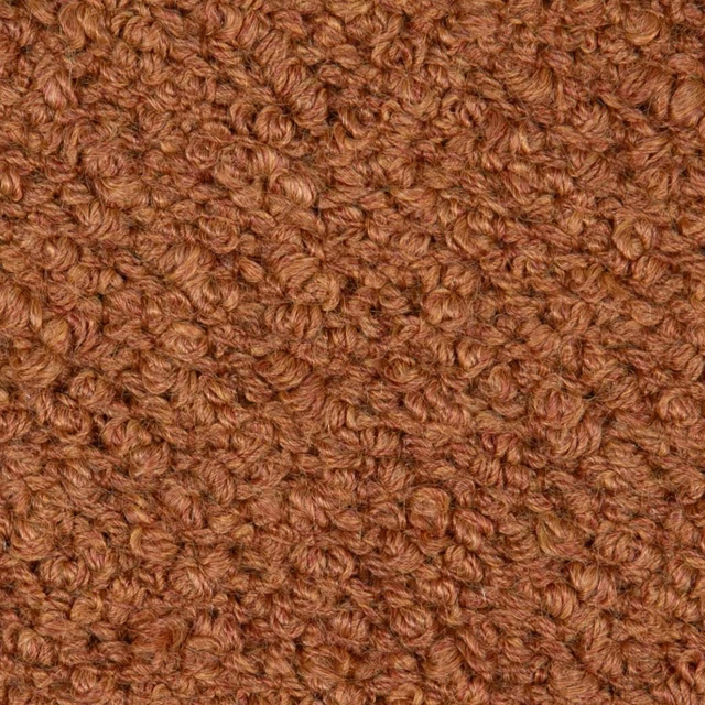 Close-up of densely looped terracotta-brown bouclé texture with subtle tonal variation