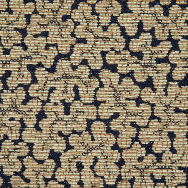 Warm sand-beige woven textile with irregular deep navy coral-like shapes and ridged texture