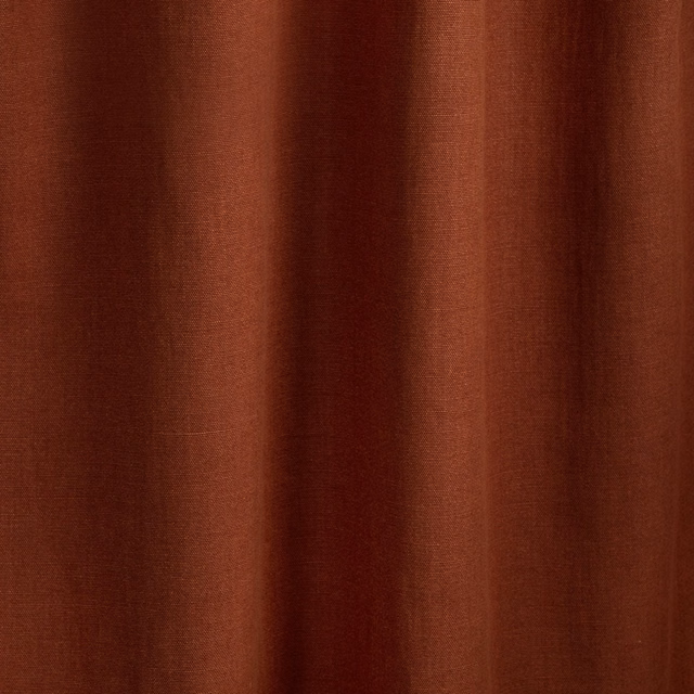 Deep brique terracotta fabric with fine vertical striations falling into soft folds