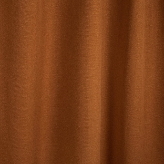 Warm terracotta plain-weave textile showing fine grain and deep vertical folds