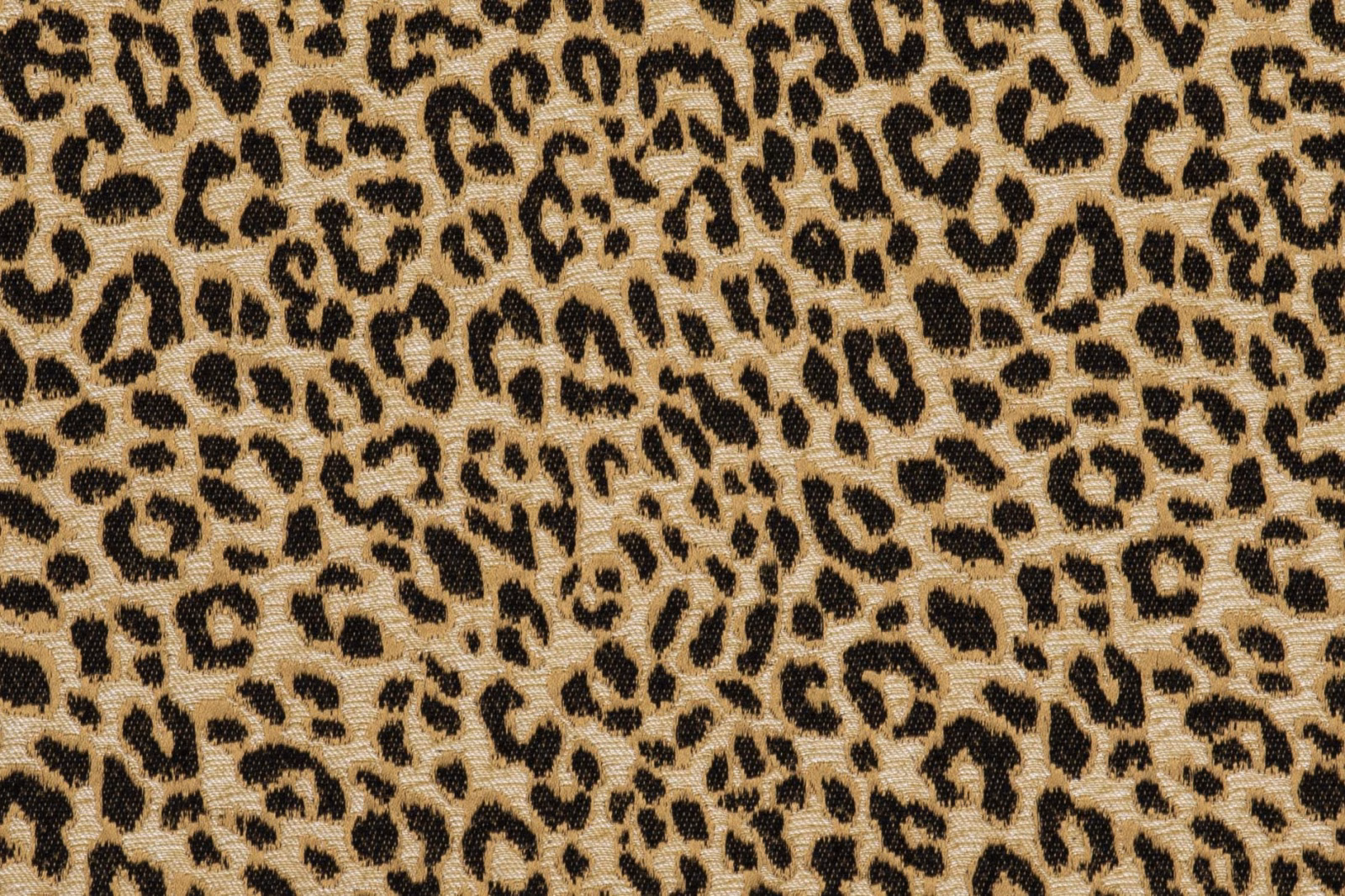 Warm beige textile with dense black and brown leopard spots and fine visible texture