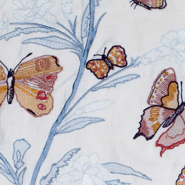 Ivory textile with blue botanical stems and ochre, pink and burgundy butterflies
