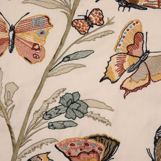 Warm ivory fabric with coral butterflies, leafy stems and muted teal botanical motifs