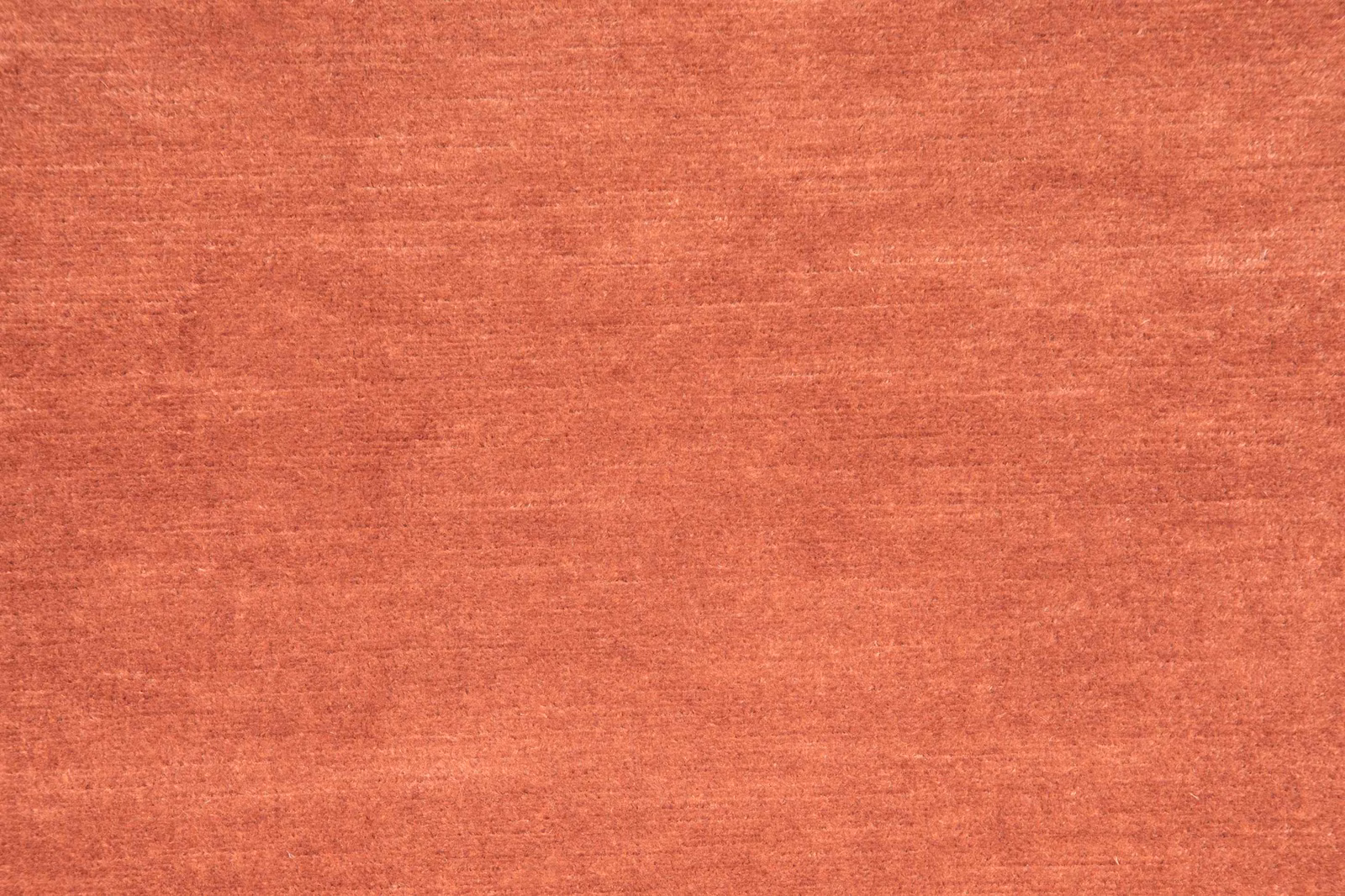 Warm acajou terracotta fabric with subtle horizontal slubbing and softly mottled woven texture