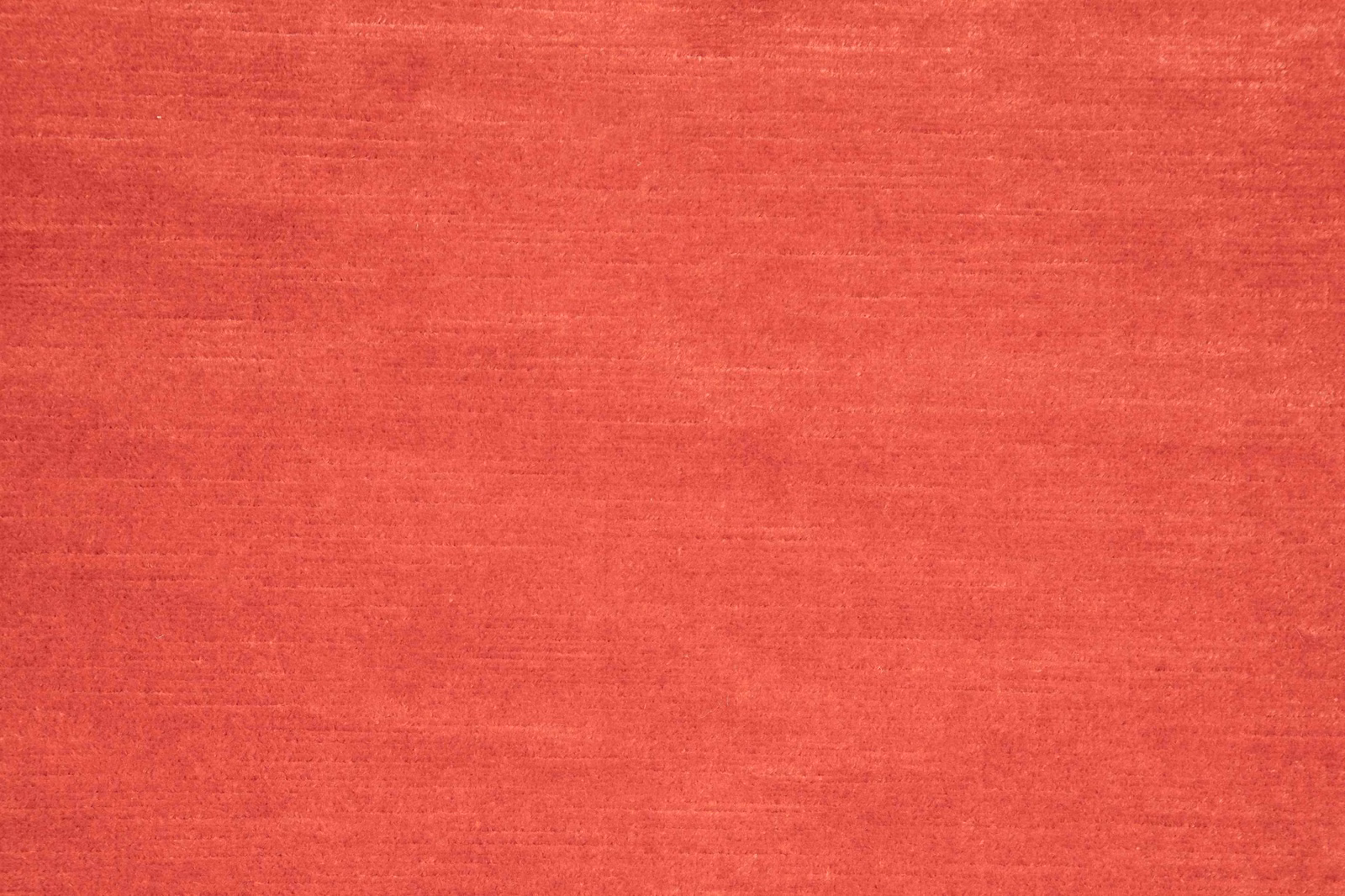 Warm coral-red fabric with subtle horizontal slub texture and tonal woven variation