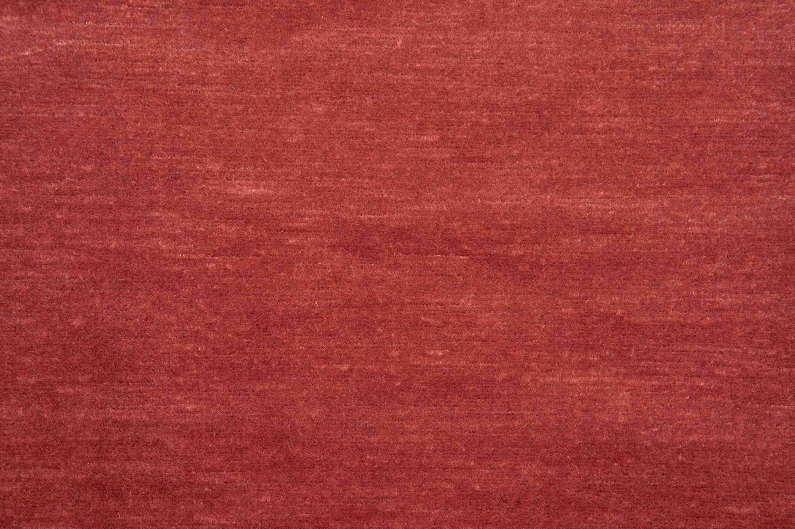 Garnet-red woven swatch with subtle horizontal slubs and softly varied tonal depth
