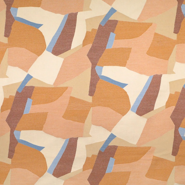 Terracotta abstract patchwork fabric with peach, cream, tan, blue and plum-brown geometric shapes