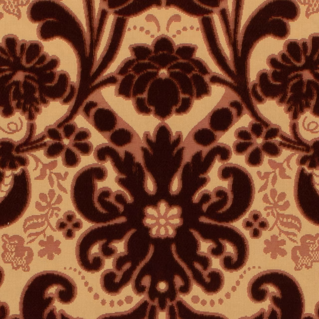 Burgundy damask floral scrolls on a warm ochre ground, close-up