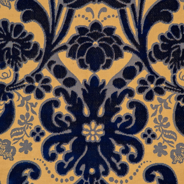 Dense navy floral scrollwork on a warm ochre ground with pale blue-grey accents