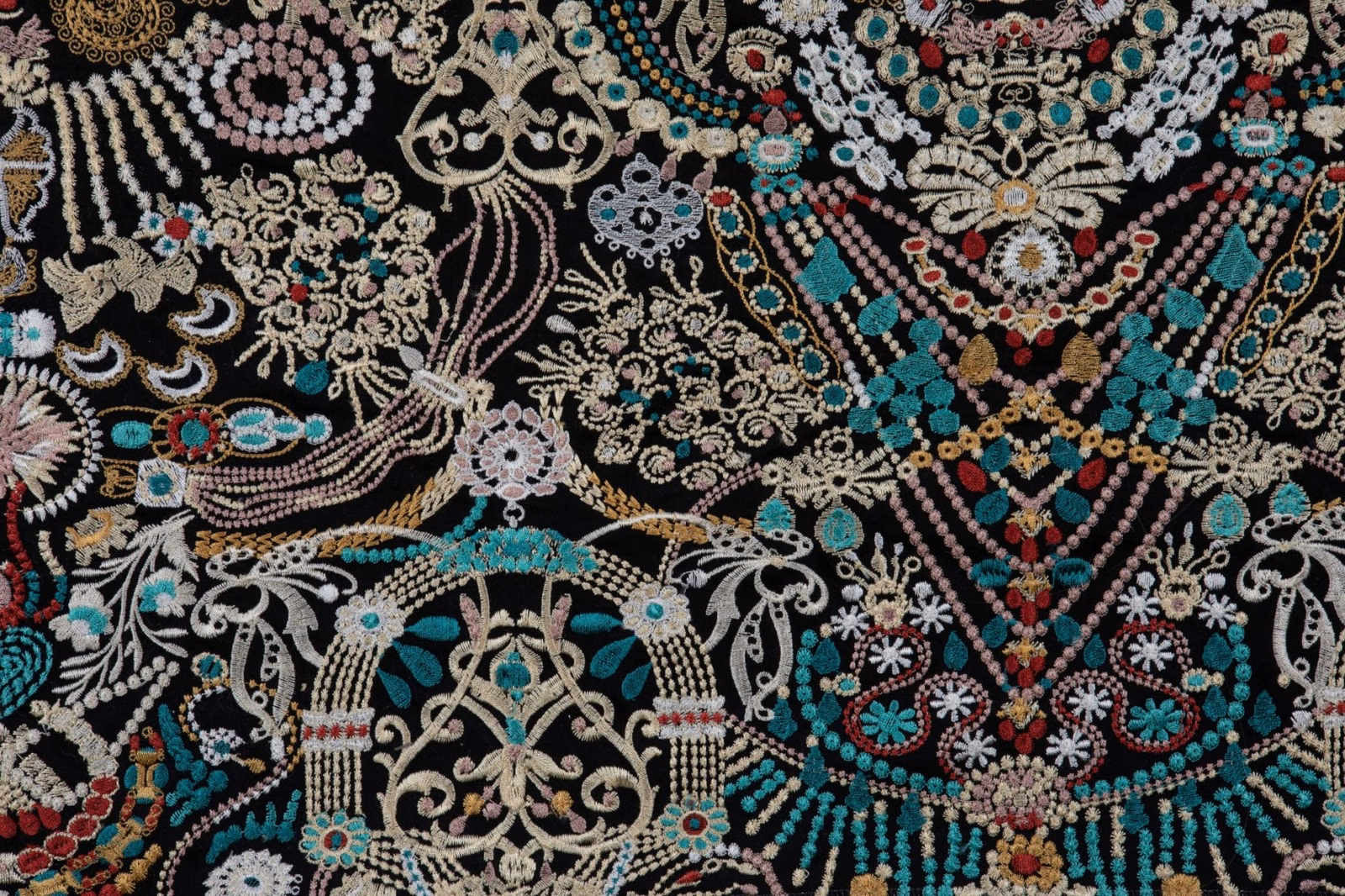 Black-ground textile with turquoise, coral, cream and gold ornamental floral motifs