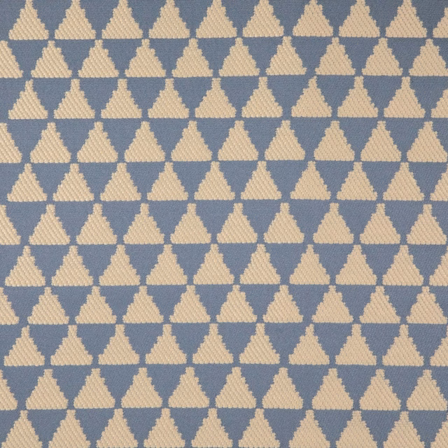 Close-up of blue-grey woven fabric with repeating cream stepped diamond motifs