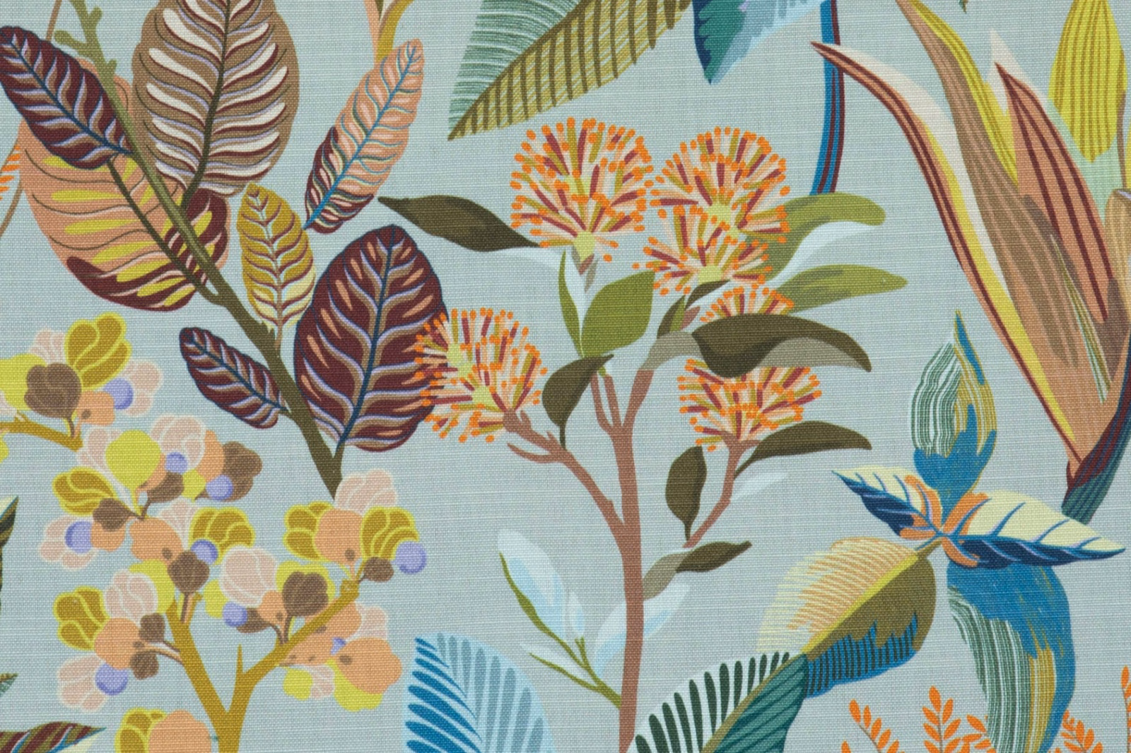Celadon botanical fabric with tropical leaves, flowers, and blue bird motifs