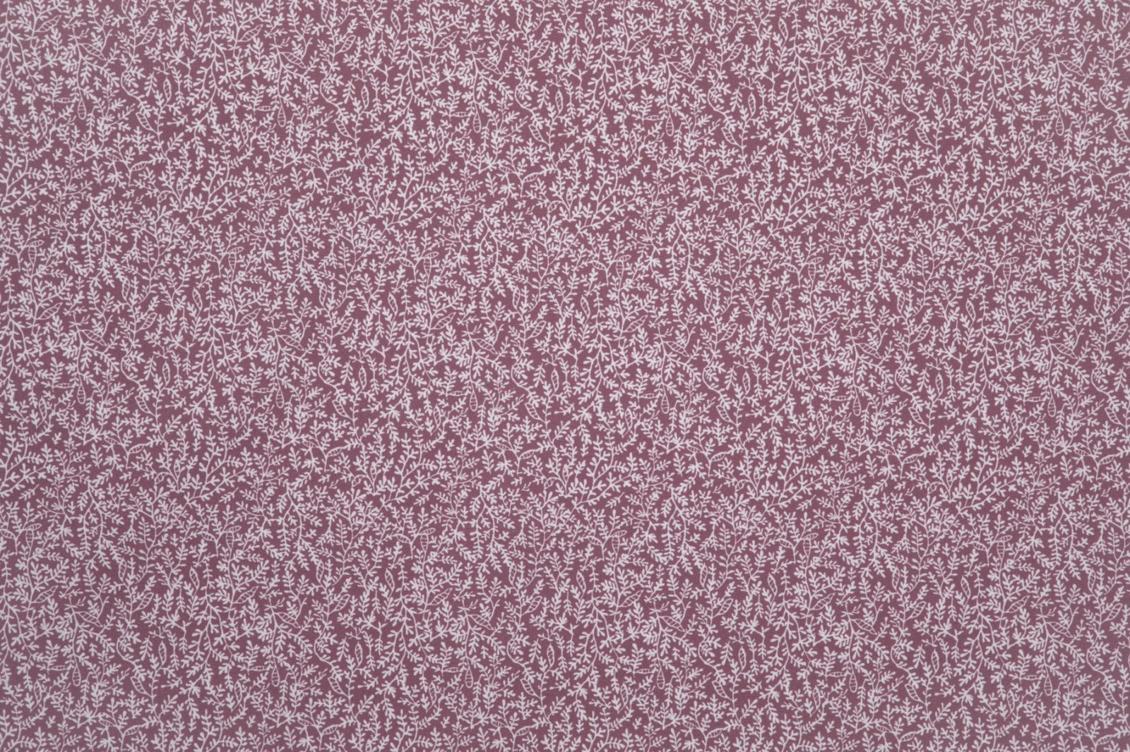 Dusty rose fabric with dense pale pink botanical tracery and a softly stippled surface
