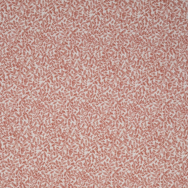 Pale blush textile covered in dense tiny muted terracotta leafy sprigs