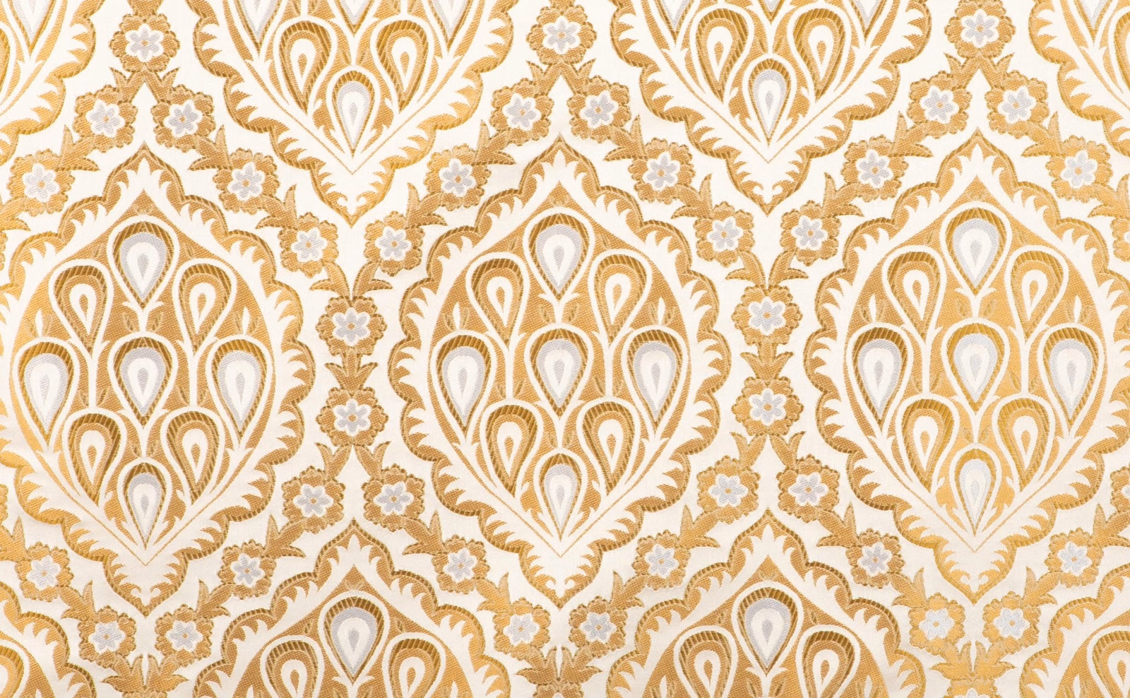 Warm gold and ivory textile with large teardrop motifs and scrolling floral detail
