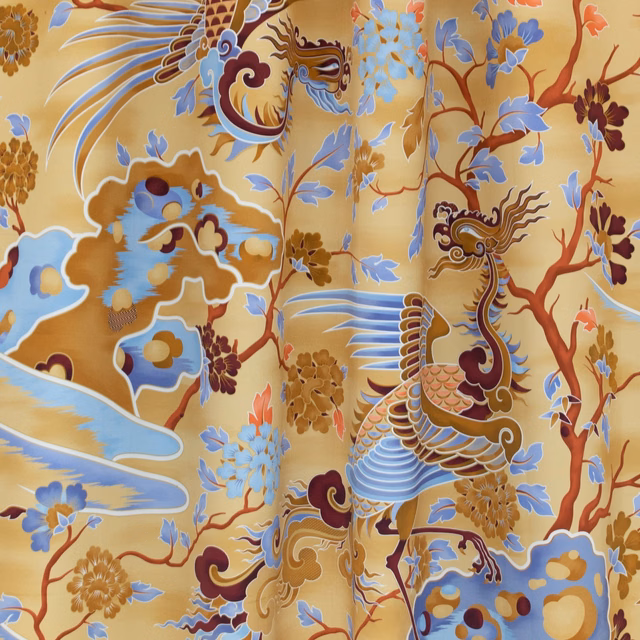 Honey-gold fabric with blue-winged birds, flowering branches and cloud motifs