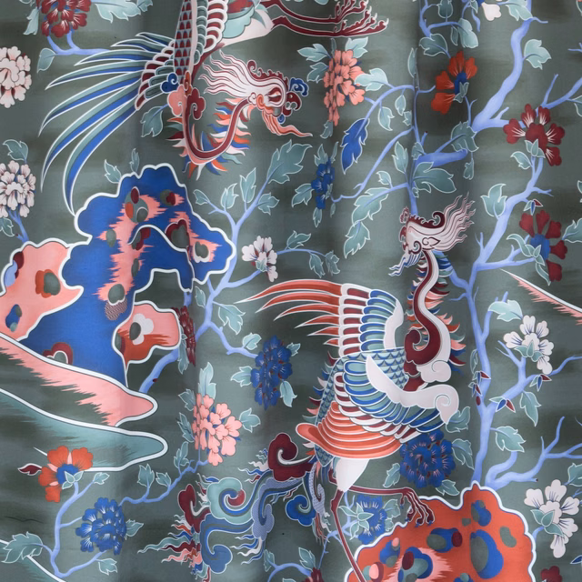 Sage-green fabric with ornate birds, coral flowers and curling botanical motifs