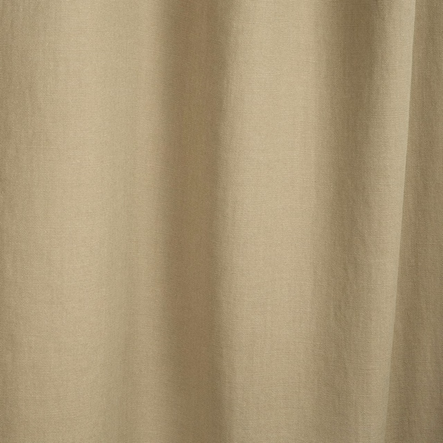 Warm beige fabric with a fine slub weave falling in soft vertical folds