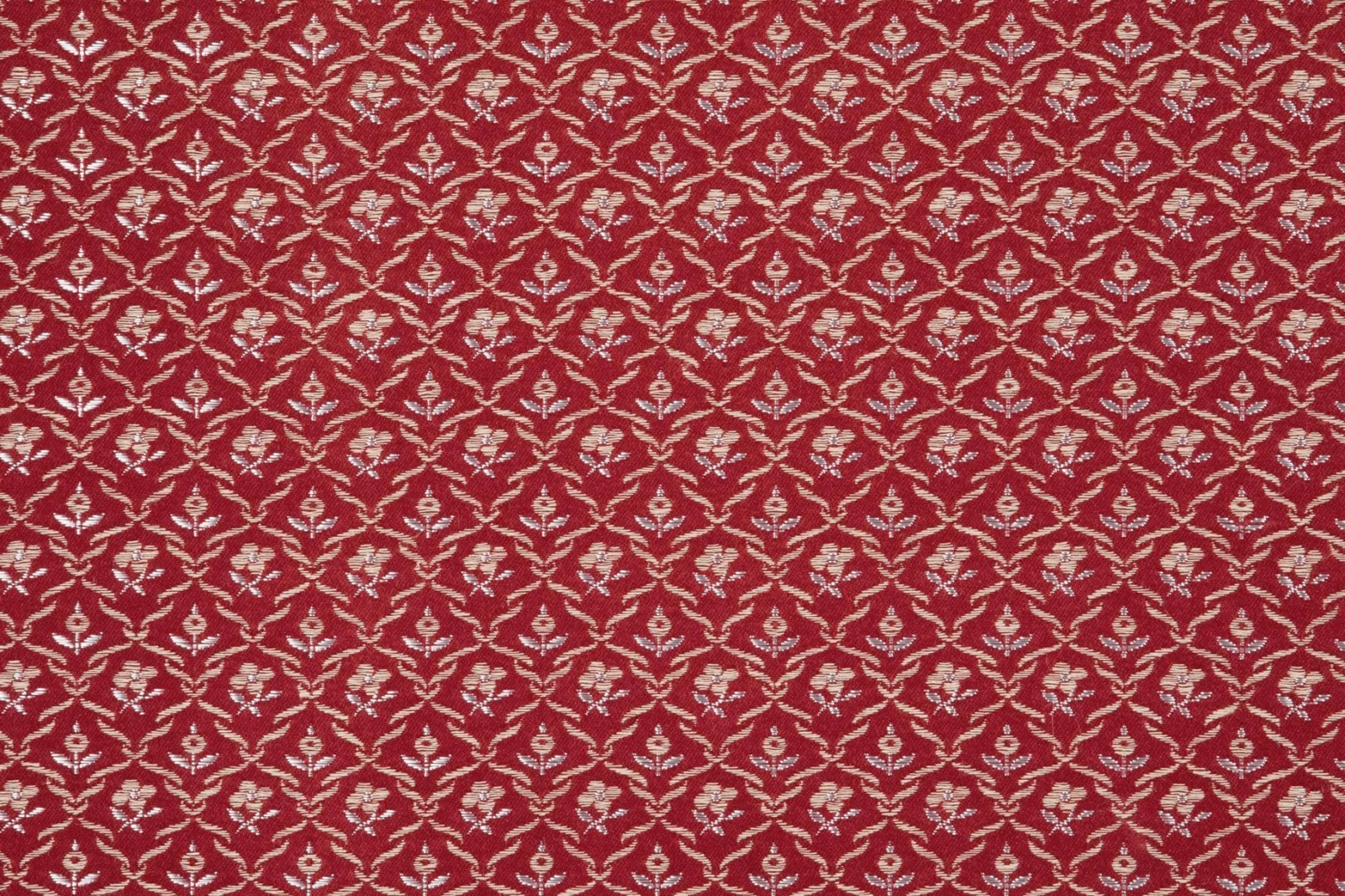 Deep garnet fabric with repeating cream floral trellis and fine woven texture