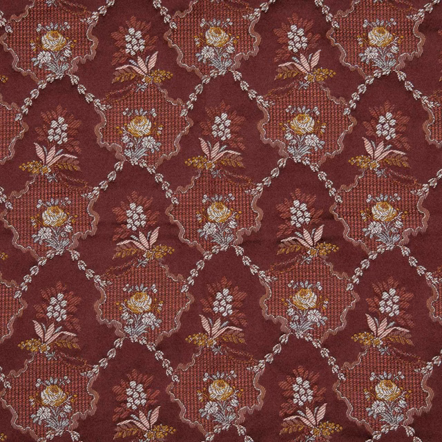 Deep garnet woven fabric with cream and gold floral bouquets in a scrolling lattice