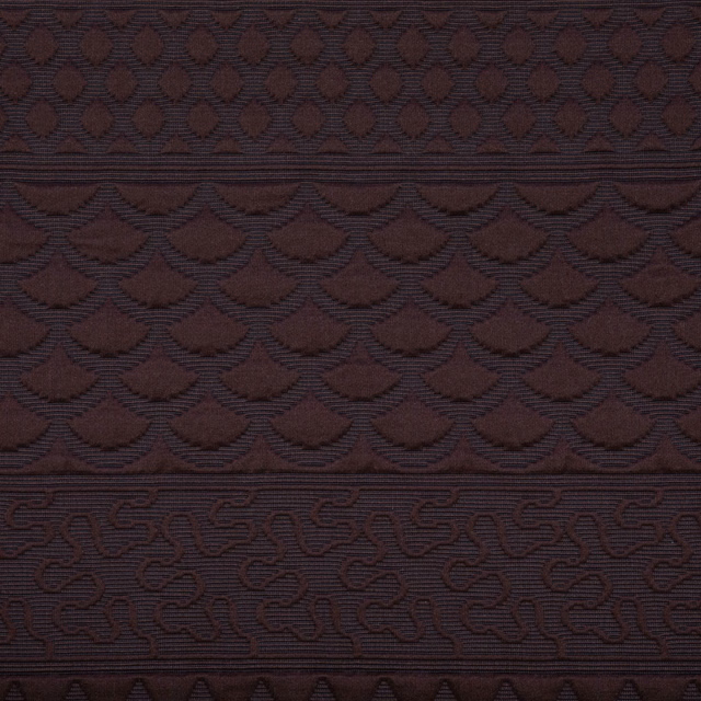 Dark burgundy woven textile with scalloped fan bands and scrolling geometric border