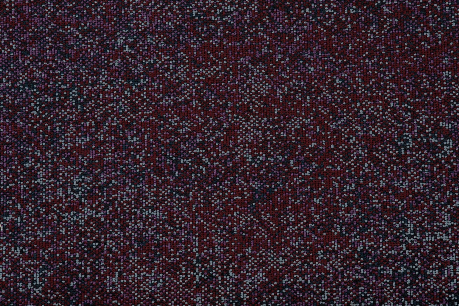 Deep prune woven textile with blue-grey flecks and granular texture