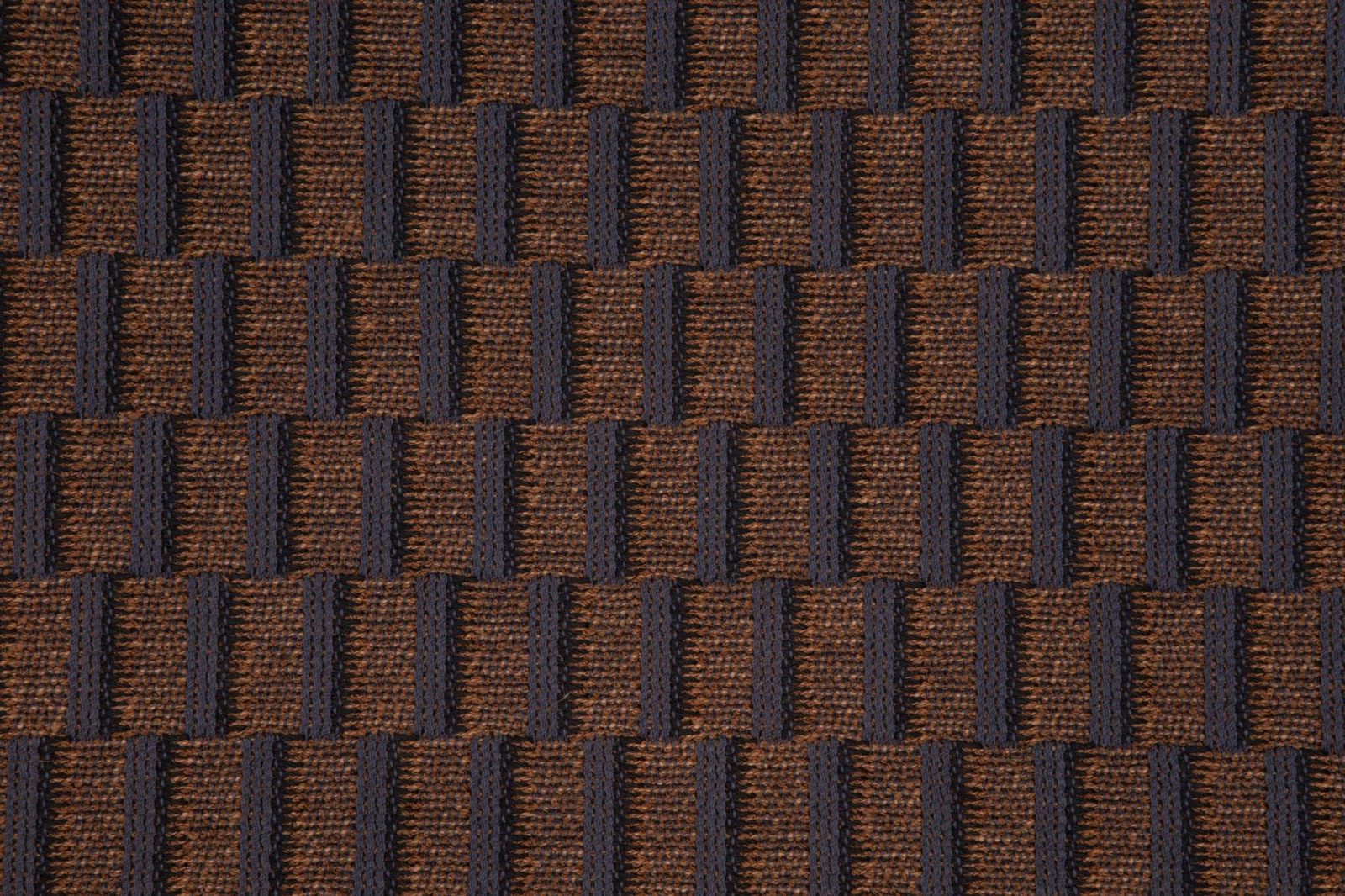 Charcoal and tobacco-brown woven blocks with a raised, tactile surface