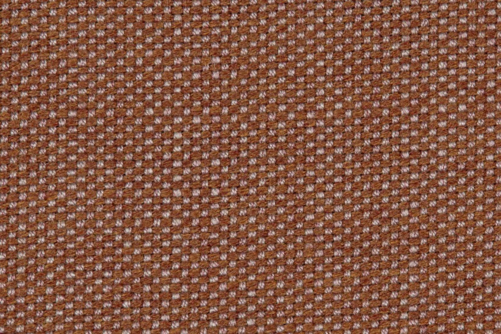 Close-up of russet brown upholstery weave with dusty rose geometric flecks