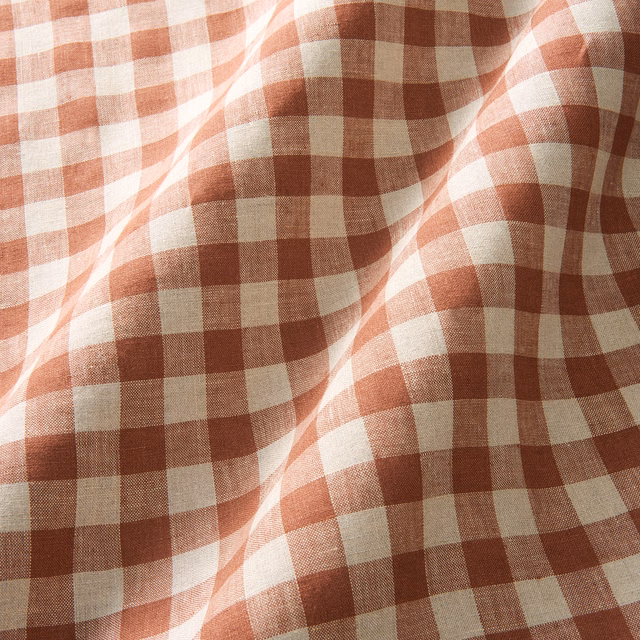 Warm ember-red and cream checks across a softly rippled linen weave