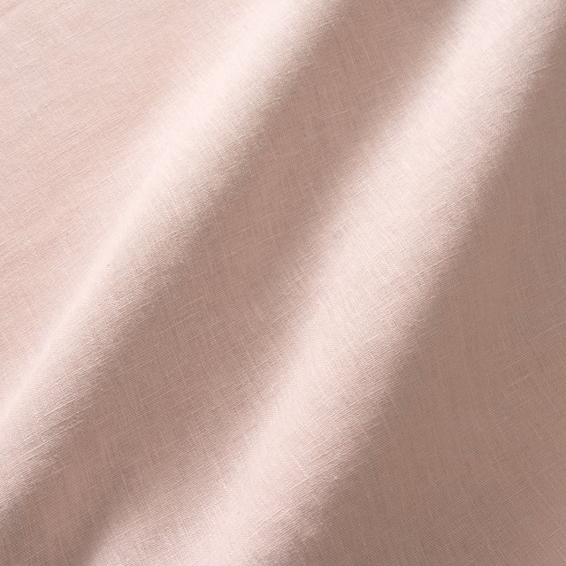 Dusty blush pink linen with fine crossweave texture and softly shaded curtain-like folds