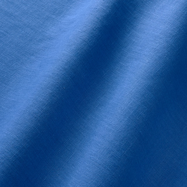 Close-up of cobalt blue linen with fine crosshatch weave and tonal folds