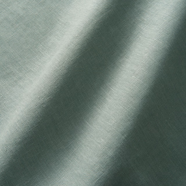Muted lichen-green linen with fine plain weave and softly shaded draped folds