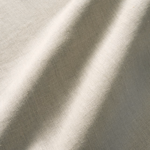 Pale greige plain linen with fine crossweave and diagonal light across the swatch