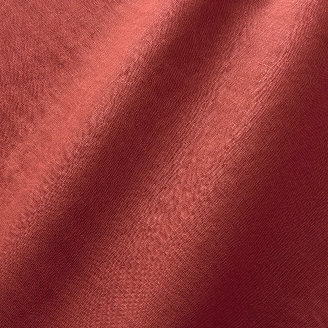 Scarlet red plain linen with coral highlights and burgundy shadowing across its fine weave