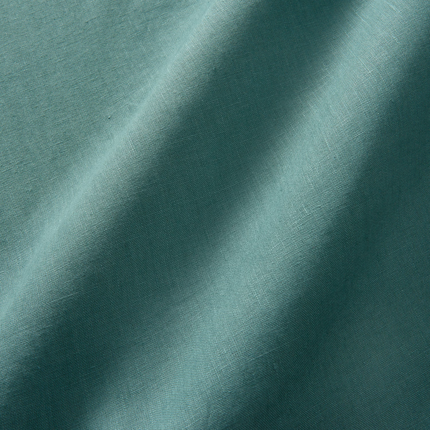Sea-green plain linen showing fine weave and tonal folds from aqua to deep teal