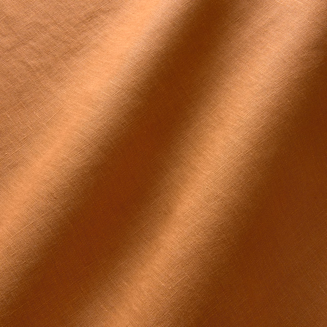 Warm spice terracotta linen with fine plain crosshatch weave and softly shaded folds