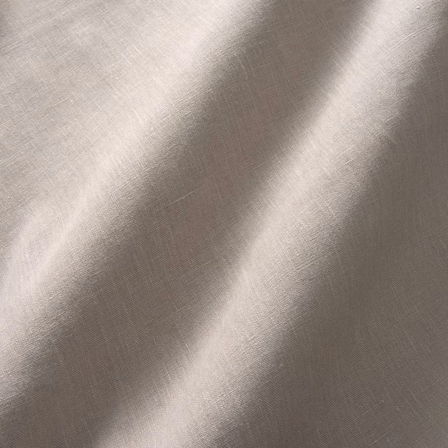Close view of muted taupe-grey linen plain weave with soft diagonal folds
