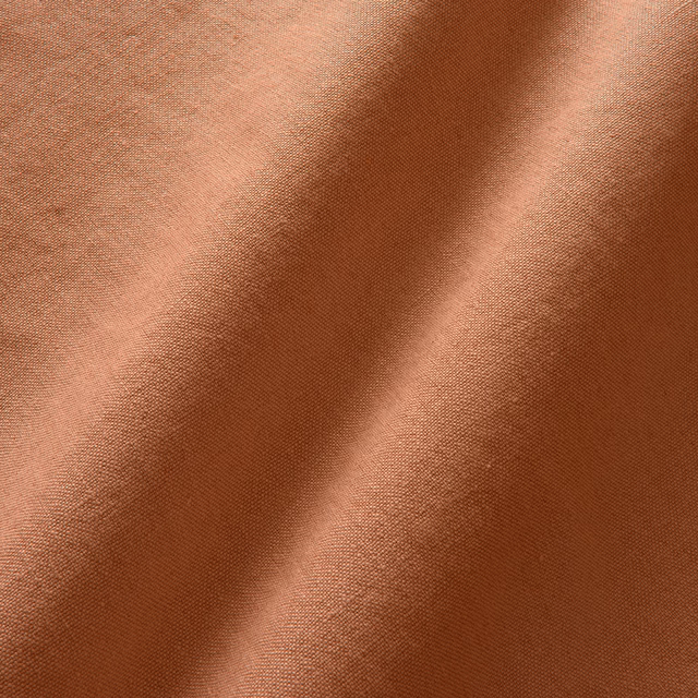 Warm cayenne linen with fine crossweave and softly shaded folded surface