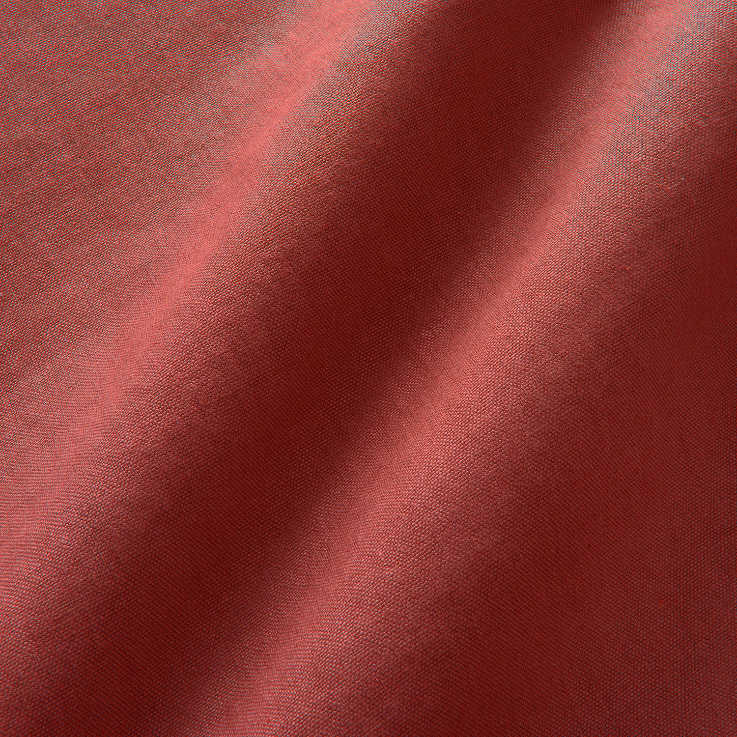 Close-up of deep cherry-red plain linen with fine weave and soft folded shadows