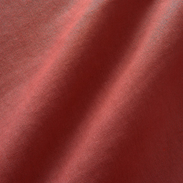 Close-up of deep cherry-red plain linen with fine weave and soft folded shadows