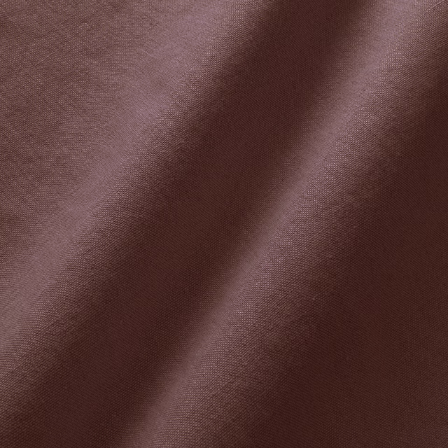 Close-up of deep damson linen with a fine plain weave and soft folds