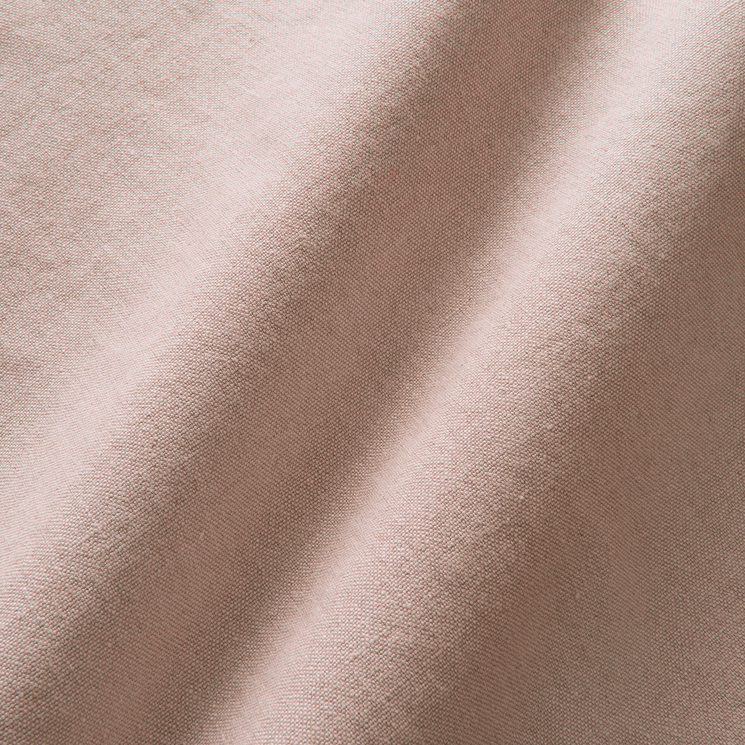 Close-up of muted dusty pink linen with a fine, softly irregular woven texture