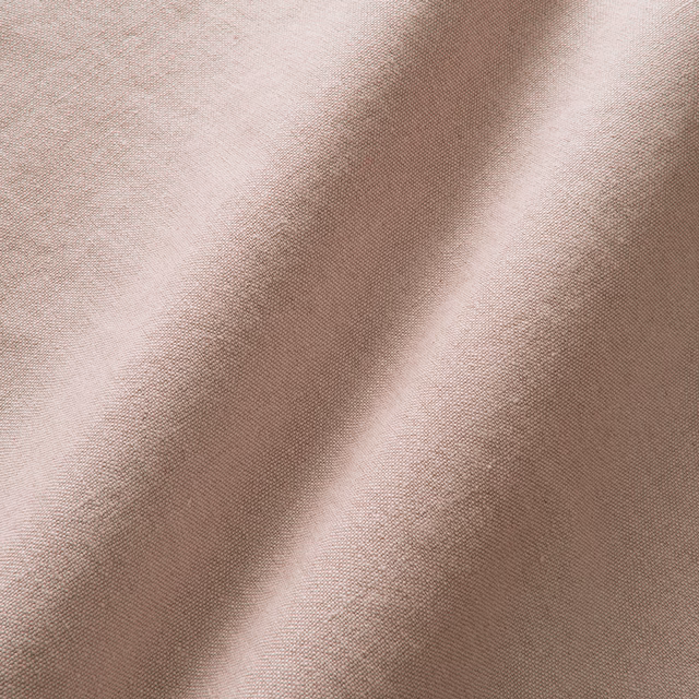 Close-up of muted dusty pink linen with a fine, softly irregular woven texture