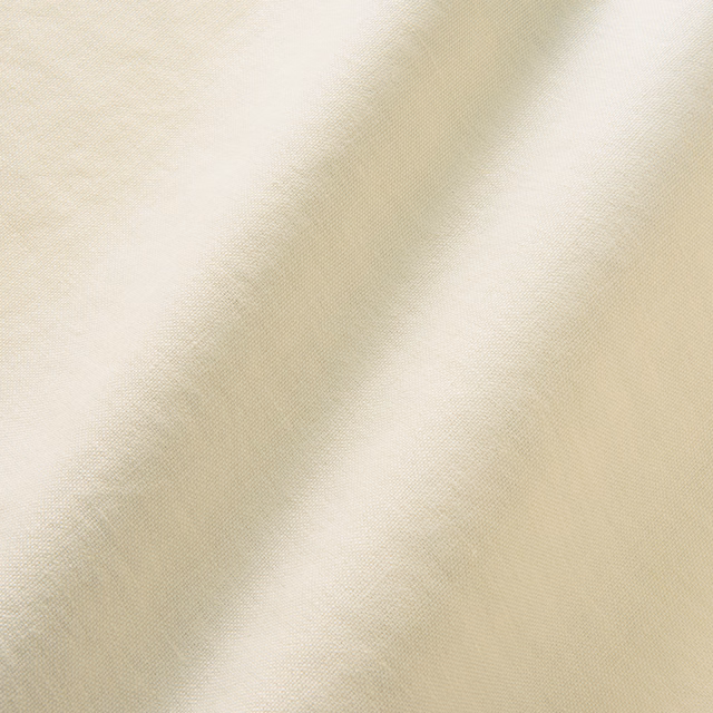 Close-up of warm eggshell linen with fine plain weave and softly mottled cream shading