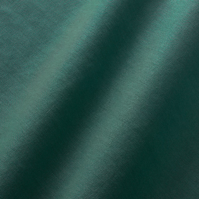 Deep forest-green plain linen with fine weave and diagonal fold shading